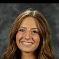 Person smiling in front of dark background